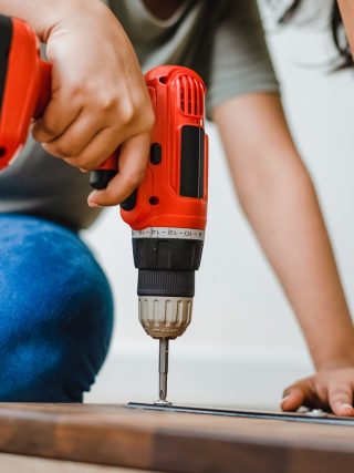Woman uses drill on wood