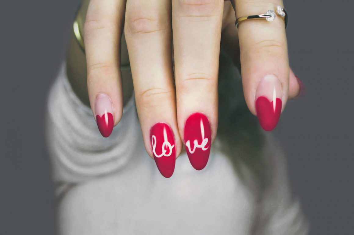 Woman with nail polish and love written on nails