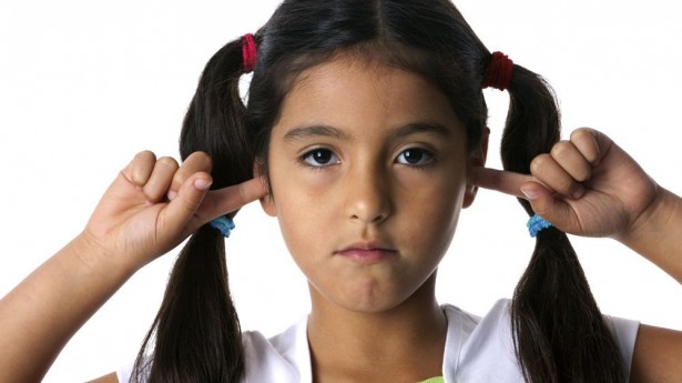 Little girl with fingers in ears