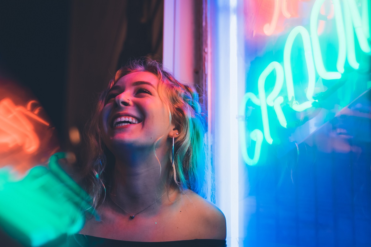 Woman under neon sign laughing